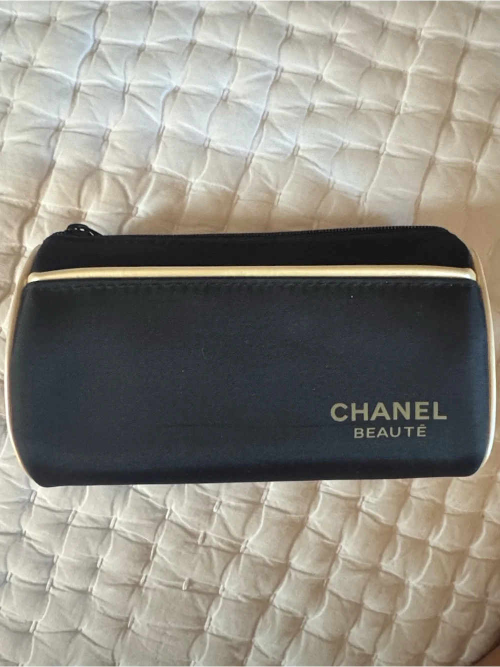 CHANEL Beauté Black and Cream Makeup Pouch and skincare products.